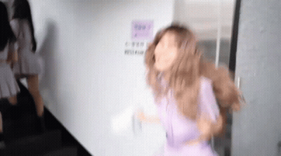 Woman In Purple Dress Standing In Front Of Door GIF