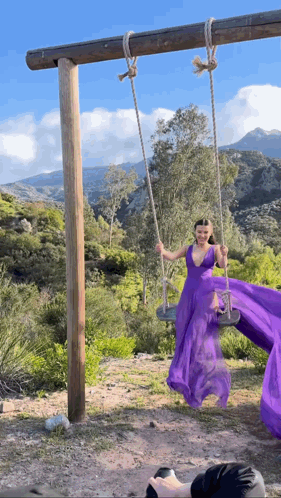 Woman In Purple Dress Swinging On Swing GIF