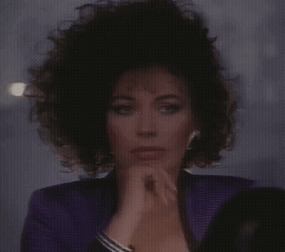 Woman In Purple Jacket Looking In Mirror GIF