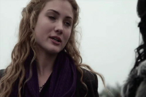 Woman In Purple Scarf And Black Jacket Talking To Man GIF
