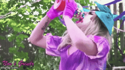 Woman In Purple Shirt Drinking From Pink Cup GIF