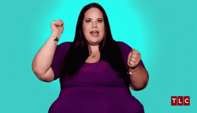 Woman In Purple Shirt Holding Fist Up GIF