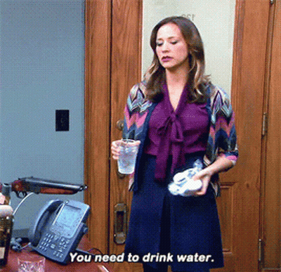 Woman In Purple Shirt Holding Water Cup GIF