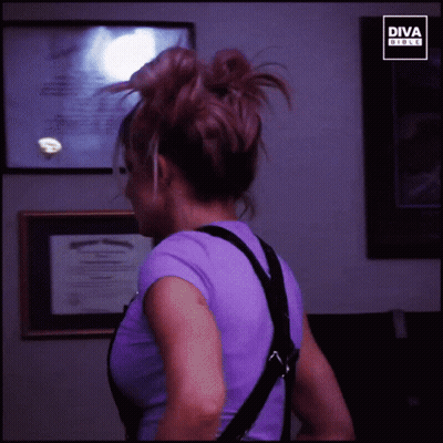 Woman In Purple Shirt In Front Of Diva Girls Sign GIF