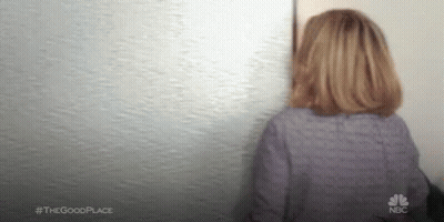 Woman In Purple Shirt Looking At Wall GIF