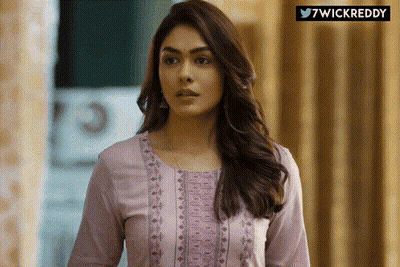 Woman In Purple Shirt Standing In Front Of 7Wickreddy Sign GIF