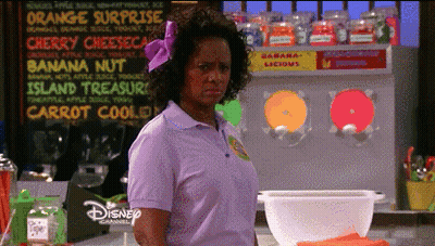Woman In Purple Shirt Standing In Front Of Banana Nut Sign GIF