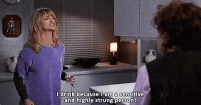 Woman In Purple Shirt Talking To Another Woman Holding Wine GIF