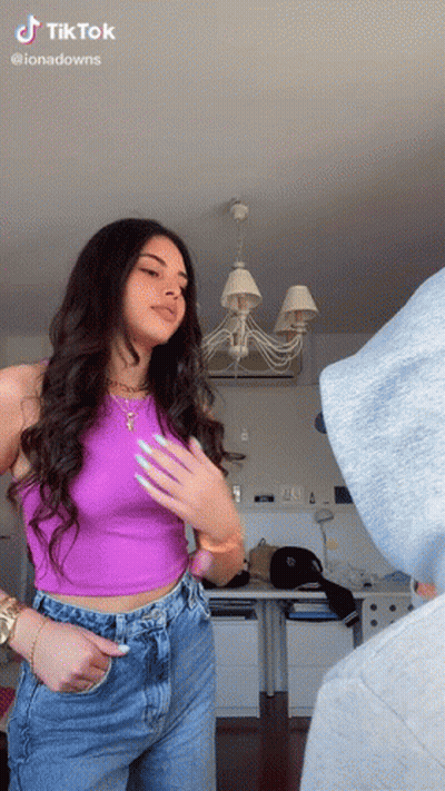 Woman In Purple Tank Top And Blue Jeans Standing In Room GIF