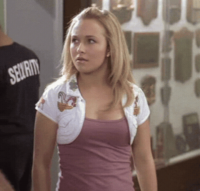 Woman In Purple Tank Top And White Jacket Standing In Front Of Man In Security Shirt GIF