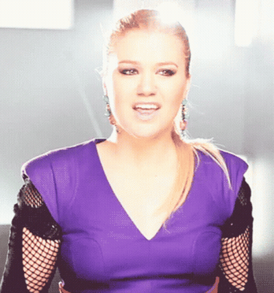 Woman In Purple Top And Black Fishnet Sleeves Singing GIF