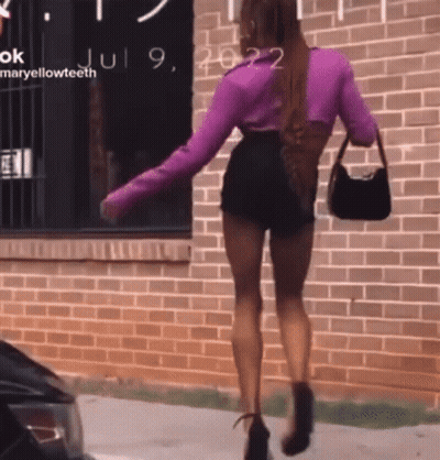 Woman in Purple Top and Black Shorts