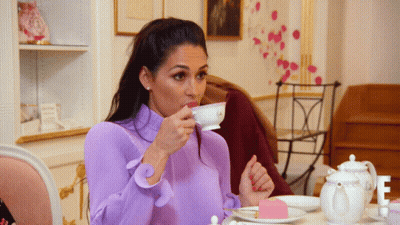 Woman In Purple Top Drinking From Cup GIF