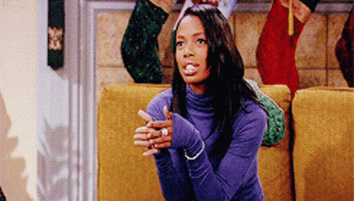 Woman In Purple Turtleneck Sitting On Yellow Couch GIF