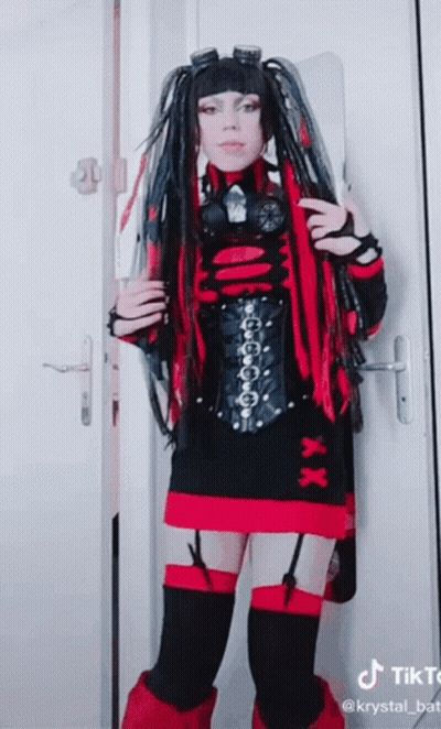 Woman In Red And Black Costume In Front Of Door With TikTok Logo GIF
