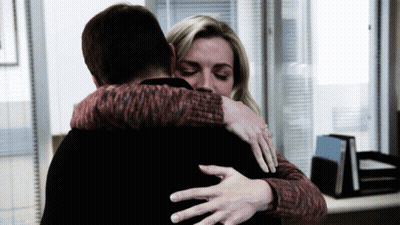 Woman In Red And Black Sweater Hugging Man In Black Shirt GIF