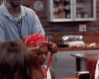Woman In Red Bandana Helped By Man In Kitchen GIF