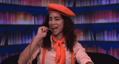 Woman In Red Beret And Orange Suspenders Eating GIF