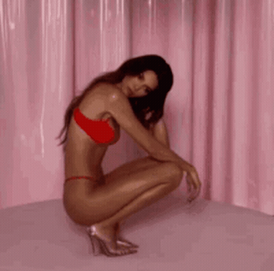 Woman In Red Bikini And Heels Squatting On Bed GIF