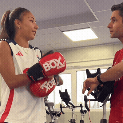 Woman In Red Boxing Gloves Talking To Man GIF