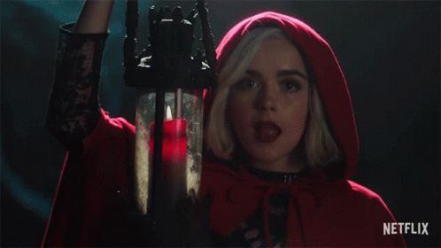 Woman In Red Cape Holding Candle With Netflix Logo GIF