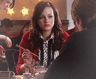 Woman In Red Cardigan Sitting At Table With Chopsticks GIF