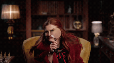 Woman In Red Coat Holding Magnifying Glass GIF