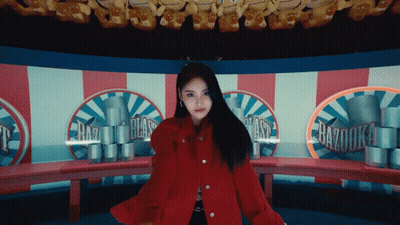 Woman In Red Coat In Front Of Razooka Carousel GIF