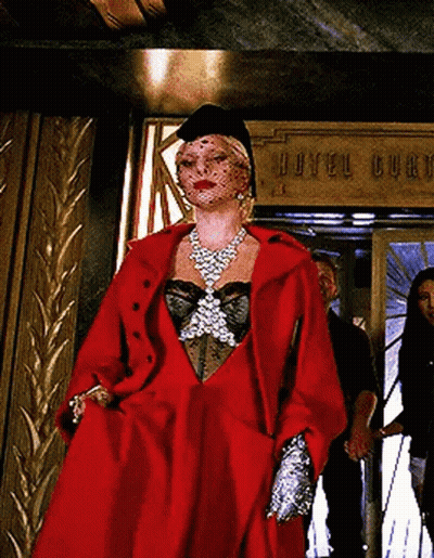 Woman In Red Coat Standing In Front Of Hotel Burch Sign GIF