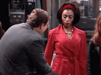 Woman In Red Coat Talking To Man GIF