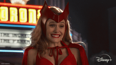 Woman In Red Costume Smiling In Front Of Orion Sign GIF