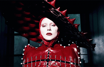 Woman In Red Costume With Spikes And Nails GIF