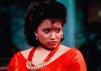 Woman in Red Dress and Gold Necklace Looking at Camera