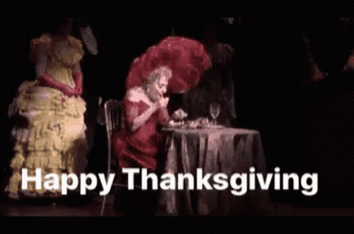 Woman In Red Dress At Table Saying Happy Thanksgiving GIF