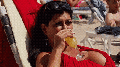 Woman In Red Dress Drinking On Beach Chair GIF