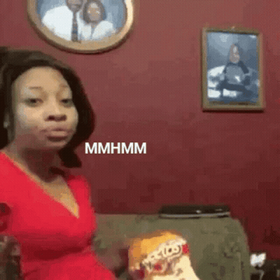 Woman In Red Dress Eating Chips On Couch GIF