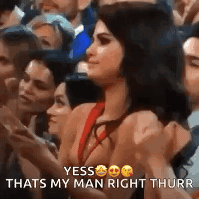Woman In Red Dress Giving Thumbs Up In Crowd GIF