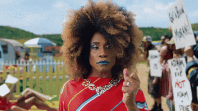 Woman In Red Dress Holding Go Back Sign GIF