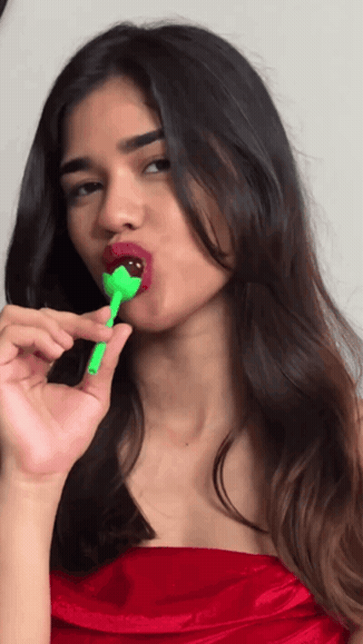 Woman In Red Dress Holding Green Lollipop GIF