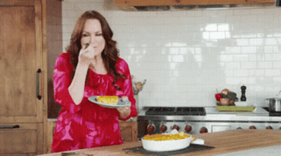 Woman In Red Dress Holding Plate Of Food GIF