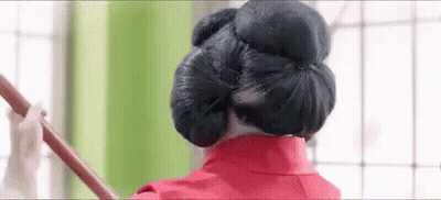 Woman In Red Dress Holding Wooden Stick In Hair GIF