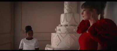 Woman In Red Dress In Front Of Large White Cake GIF