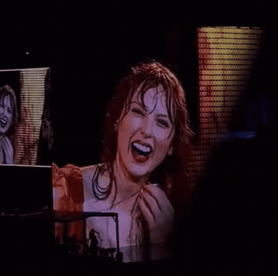 Woman In Red Dress Laughing In Front Of Screen GIF