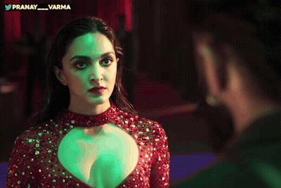 Woman In Red Dress Looking At Man In Green Light GIF