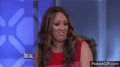 Woman In Red Dress Making Funny Face In Front Of Real Sign GIF