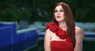 Woman In Red Dress Making Gesture GIF