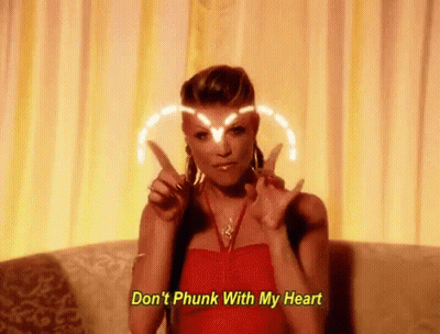 Woman In Red Dress Making Peace Sign On Couch GIF