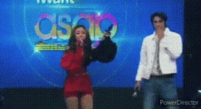 Woman In Red Dress Next To Man In White Jacket GIF