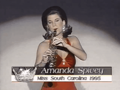 Woman In Red Dress Playing Saxophone With Miss South Carolina Crown GIF