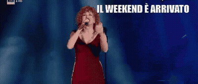 Woman In Red Dress Singing Into Microphone Il Weekend E Arrivato Che Sia Benedetto GIF